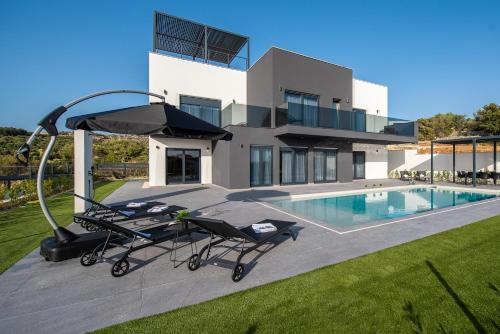 a villa with a swimming pool and a house at Villa Aria in Novalja