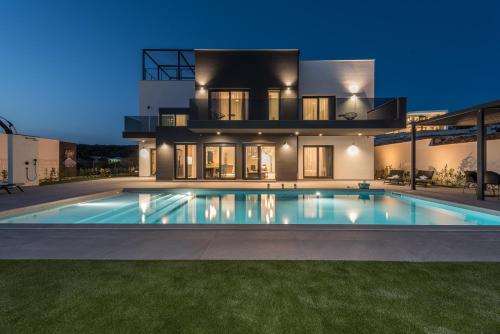 a villa with a swimming pool in front of a house at Villa Aria in Novalja