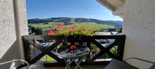 a balcony with a table with flowers on it at Hotel Magdalenenhof inklusive MeineCardPlus in Willingen