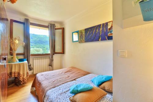 a bedroom with a bed with two pillows and a window at La Maison De Noelie - stunning house for rent in Le Bar-sur-Loup
