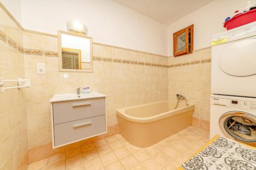 a bathroom with a tub and a sink and a washing machine at Listed Accomodation 4 At 300m river 800m village and 30mn Nice Cannes Antibes in Le Bar-sur-Loup