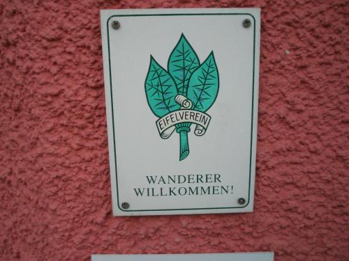 a sign on a wall with a wanderer wanderer willushima istg at Landhotel am Wenzelbach in Prüm