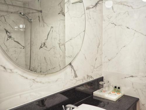 een witte marmeren badkamer met een spiegel en een wastafel bij Best Beach Villa in Pattaya