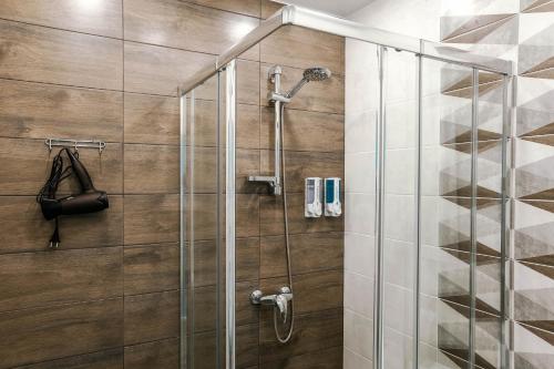 uma casa de banho com um chuveiro e uma porta de vidro em Апартаменты Небо возле Аэропорта на 2 гостя em Irkutsk