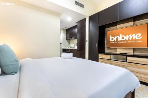 a hotel room with a bed and a television at bnbmehomes - Merano Tower in Dubai
