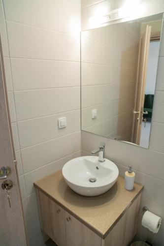 a bathroom with a sink and a mirror at Hello Village Chania in SFakianalíon