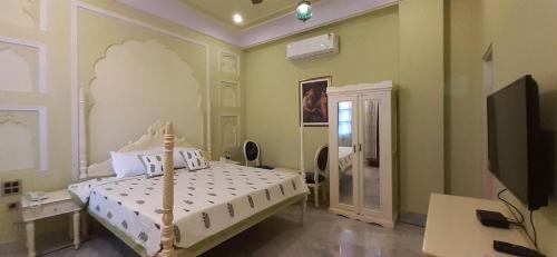 a bedroom with a bed and a tv in it at Raj Rajeshwari Haveli in Jaipur