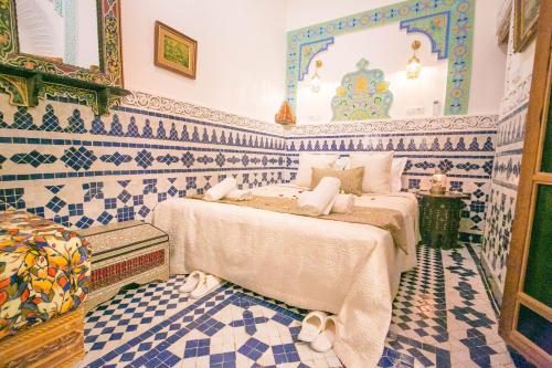 2 camas en una habitación con azulejos azules y blancos en Palais Fes Yahya en Fès al Bali