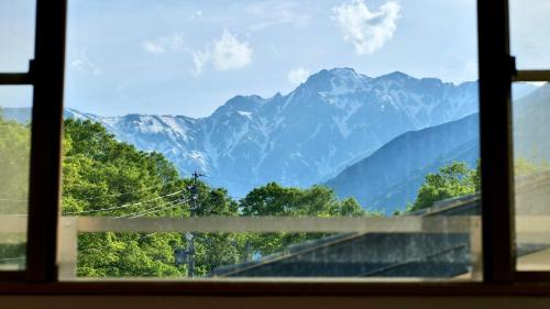 a view of mountains from a window at Hotel Oak Forest in Hakuba