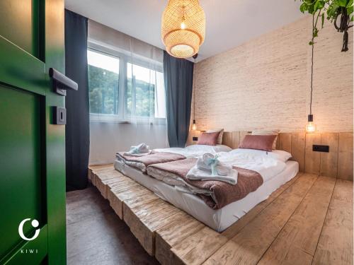 a bedroom with a large bed on a wooden floor at JUMBO APARTMENTS in Rajecké Teplice