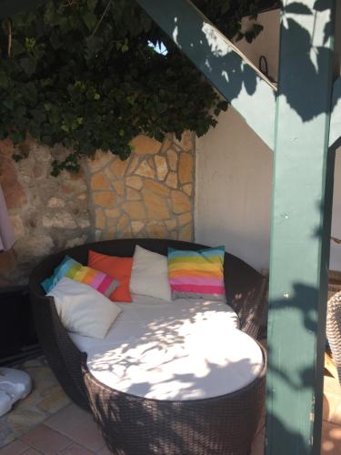 una silla de mimbre con almohadas coloridas en el patio en Mandula House, en Paloznak