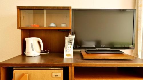 a desk with a television and a coffee maker on it at Hotel Oak Forest in Hakuba