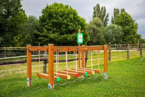 a playground with a wooden bench in the grass at Agriturismo L'Acero Rosso in Sacile