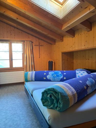 1 dormitorio con 2 camas en una cabaña de madera en Ferienwohnung Stalden, en Lütschental