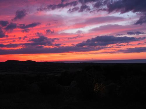 a sunset from the top of a hill at Stazzu Giasti Agriturismo in Aglientu