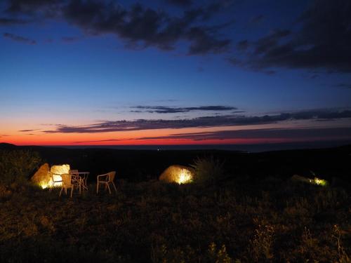a table and chairs sitting on top of a field at night at Stazzu Giasti Agriturismo in Aglientu