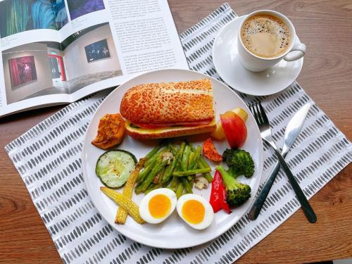 a plate of food with eggs and vegetables and a cup of coffee at Onsense Villa in Jiaoxi