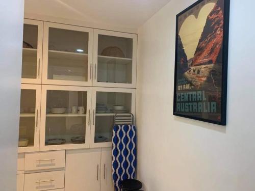a kitchen with white cabinets and a picture on the wall at Creys Condo 2 at Pico de Loro Cove in Nasugbu