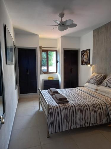 Schlafzimmer mit einem Bett und einem Deckenventilator in der Unterkunft Caleta Holiday Bungalow in Caleta de Fuste