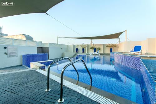 a swimming pool with blue water and blue chairs at bnbmehomes - La Fontana in Dubai