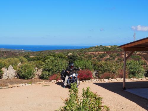 a man riding a motorcycle on a dirt road at Stazzu Giasti Agriturismo in Aglientu