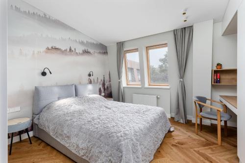 1 dormitorio con cama, escritorio y ventana en V33 cozy apartment, en Druskininkai