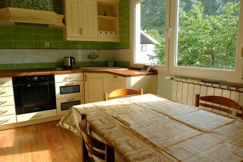 a kitchen with a table with chairs and a kitchen with green tiles at Apartment Mars in Bovec