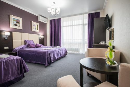 um quarto de hotel com duas camas e uma mesa em Hotel Avrora em Vityazevo