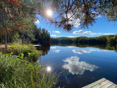 Blick auf einen See mit Bäumen und Wolken im Wasser in der Unterkunft Iken Mökit in Heinola