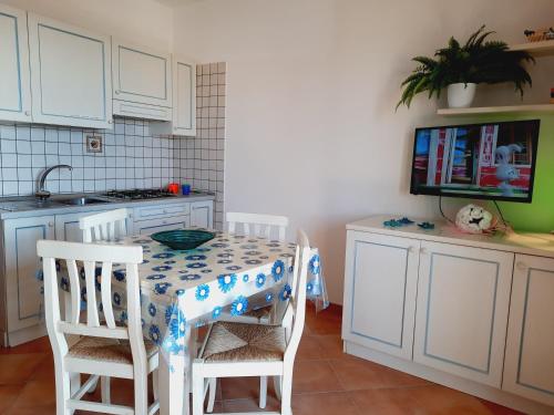 a kitchen with a table with two chairs and a sink at Case Vacanza Castello di Gallura in Santa Teresa Gallura