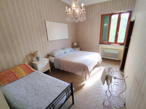 a bedroom with two beds and a chandelier at Fonte Degna - Alloggio e Sito Storico in Citerna