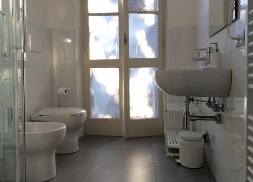 a white bathroom with a sink and a toilet at B&B L'Affresco in Mantova