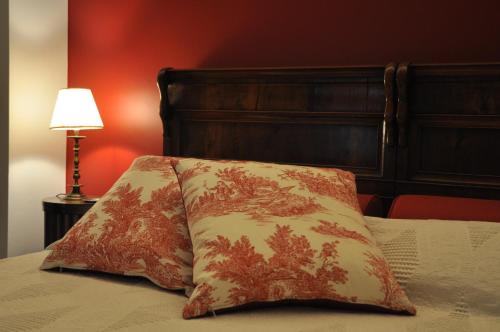 a bed with two pillows on it with a lamp at B&B L'Affresco in Mantova