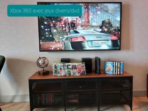 a television on a wall with a table with a tv at L'INATTENDU Vue imprenable,clim,parking avec borne de recharge, ménage inclus in Montaigu