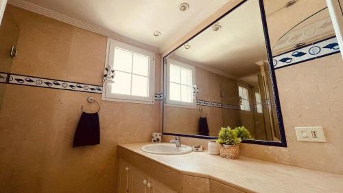 a bathroom with a sink and a large mirror at Apartments Bambu in San Agustin