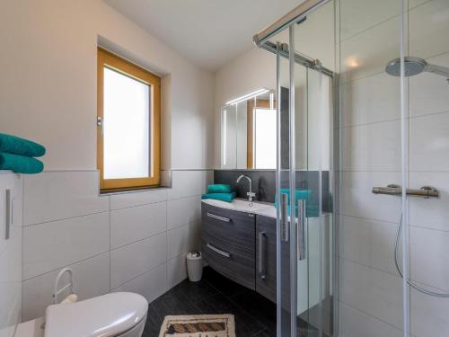een badkamer met douche, toilet en wastafel bij Haus am Waldesrand in Ellmau