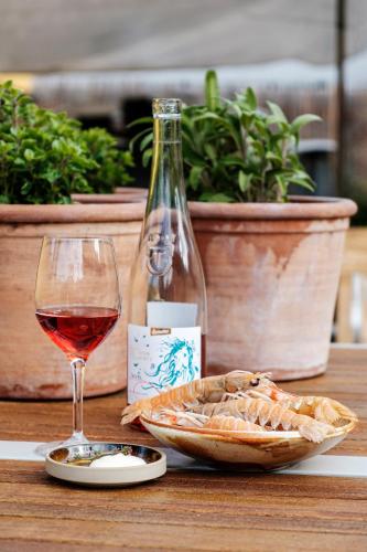 a glass of wine and a bowl of bread and a bottle at Grønbechs Hotel in Allinge