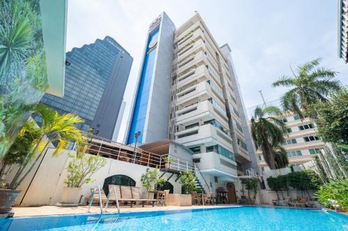 a swimming pool in front of a building at Hotel Mermaid Bangkok in Bangkok