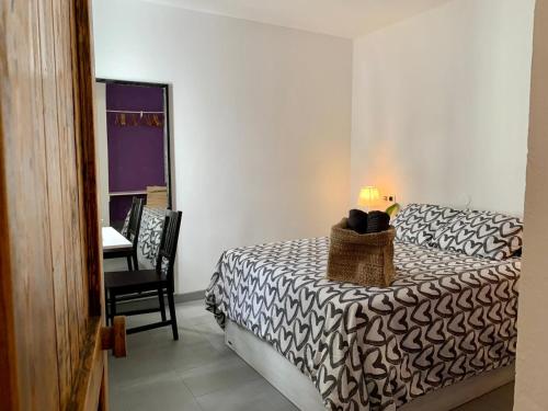 una camera da letto con un letto con una lampada e una sedia di La Casita de Galaila a Costa Calma