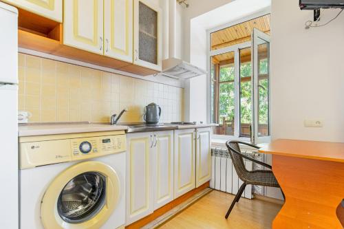a kitchen with a washing machine and a table at Best Apartment in the city centre in Odesa