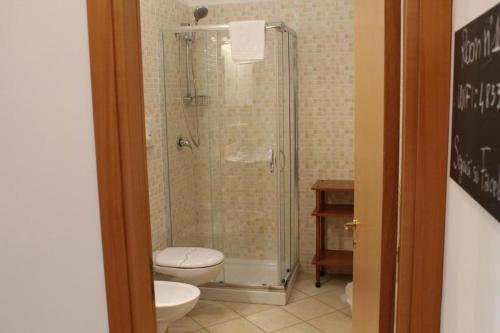 e bagno con doccia, servizi igienici e lavandino. di Colonna Rooms & apartment a Trani
