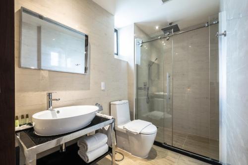 a bathroom with a sink and a toilet and a shower at Hotel Mermaid Bangkok in Bangkok