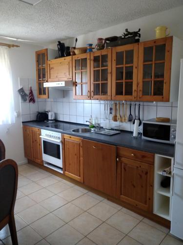 a kitchen with wooden cabinets and a black counter top at Dori's Fewo in Mittenwalde