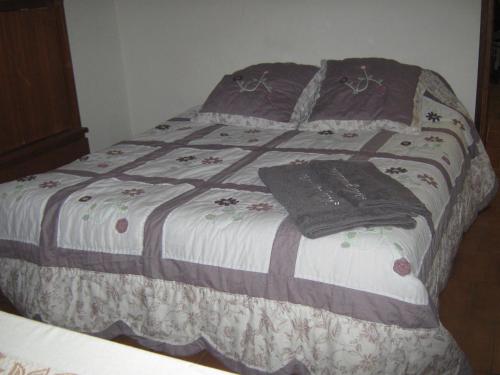 Una cama con manta y almohadas. en gite Marydidou, en Entressen