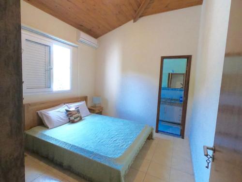 a bedroom with a bed and a mirror at Praia de Itamambuca- Casa charmosa e iluminada in Ubatuba