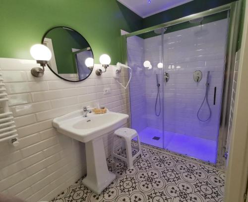 y baño con lavabo y ducha con espejo. en Opera Relais 85, en Messina