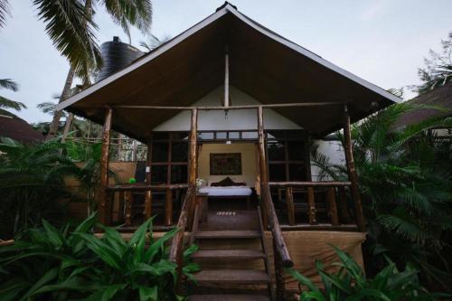a small house with stairs leading to the front of it at The Village Agonda in Agonda