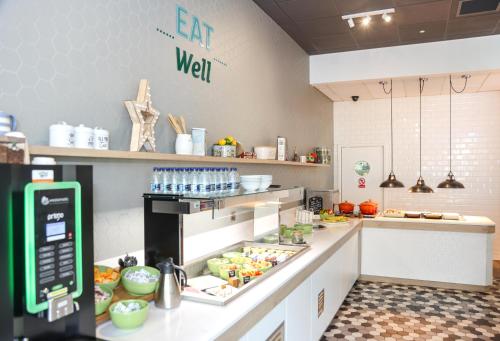 a kitchen with a counter with food on it at Holiday Inn Bournemouth by IHG in Bournemouth