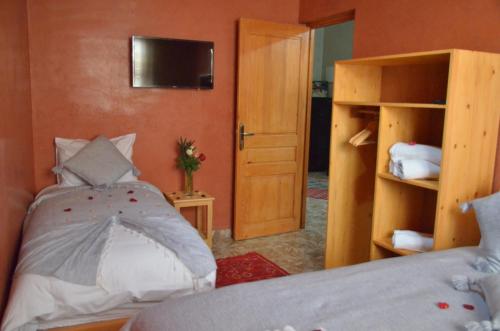 - une chambre avec un lit et une télévision murale dans l'établissement Riad Essaouira, à Essaouira