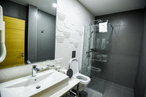 a bathroom with a sink and a toilet and a mirror at Hotel Park Shtip in Štip